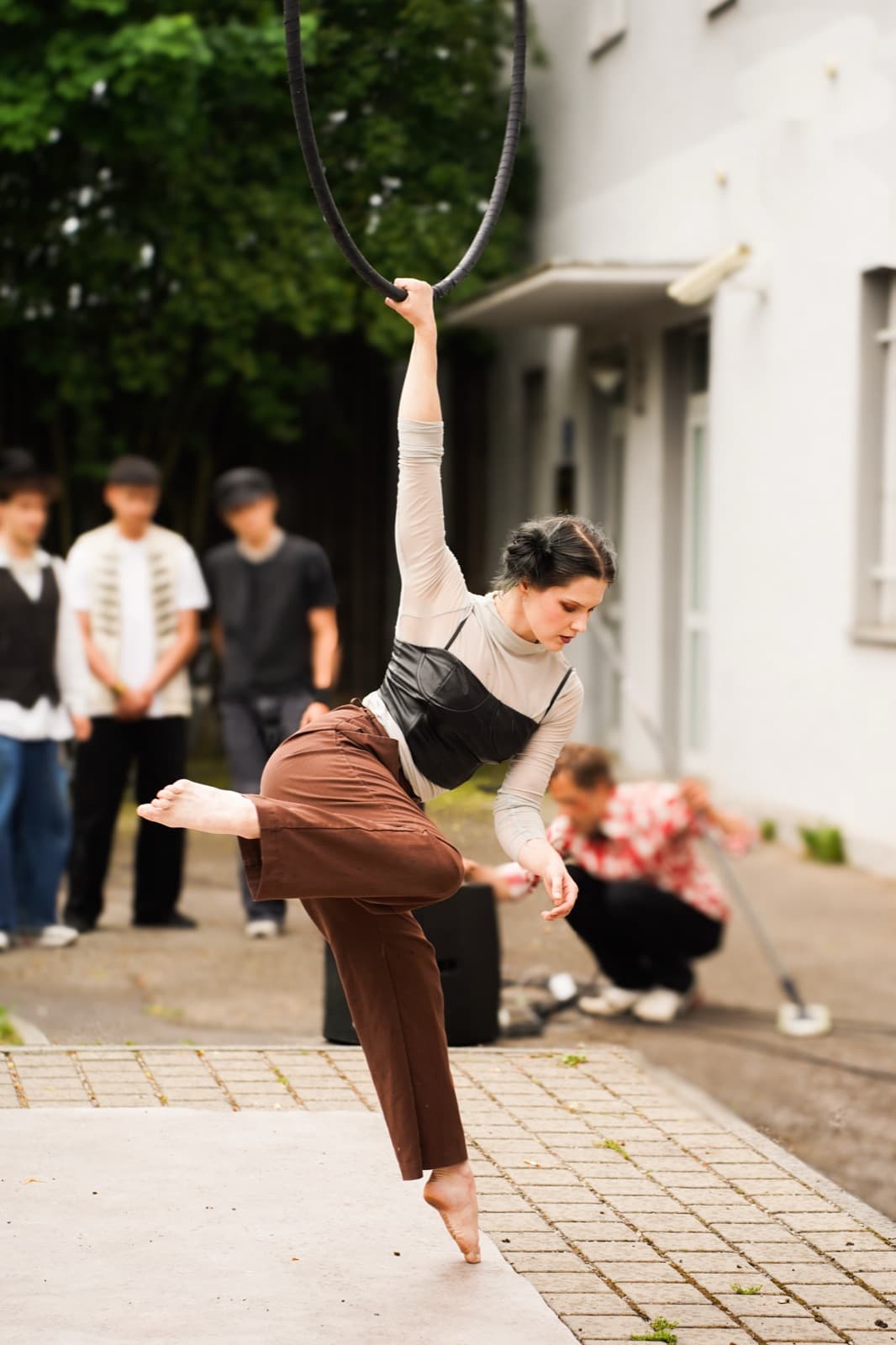 Artistin hängt am Aerial Hoop und streckt ein Bein zur Seite